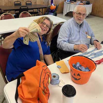 People at table with bags of money