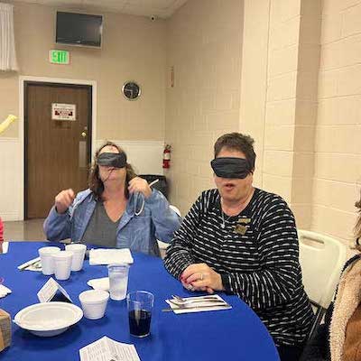 2 blindfolded women eating