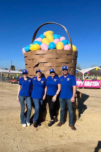 Volunteers by large Easter basket.